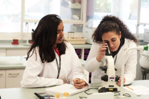 2 girls in science using magnifier