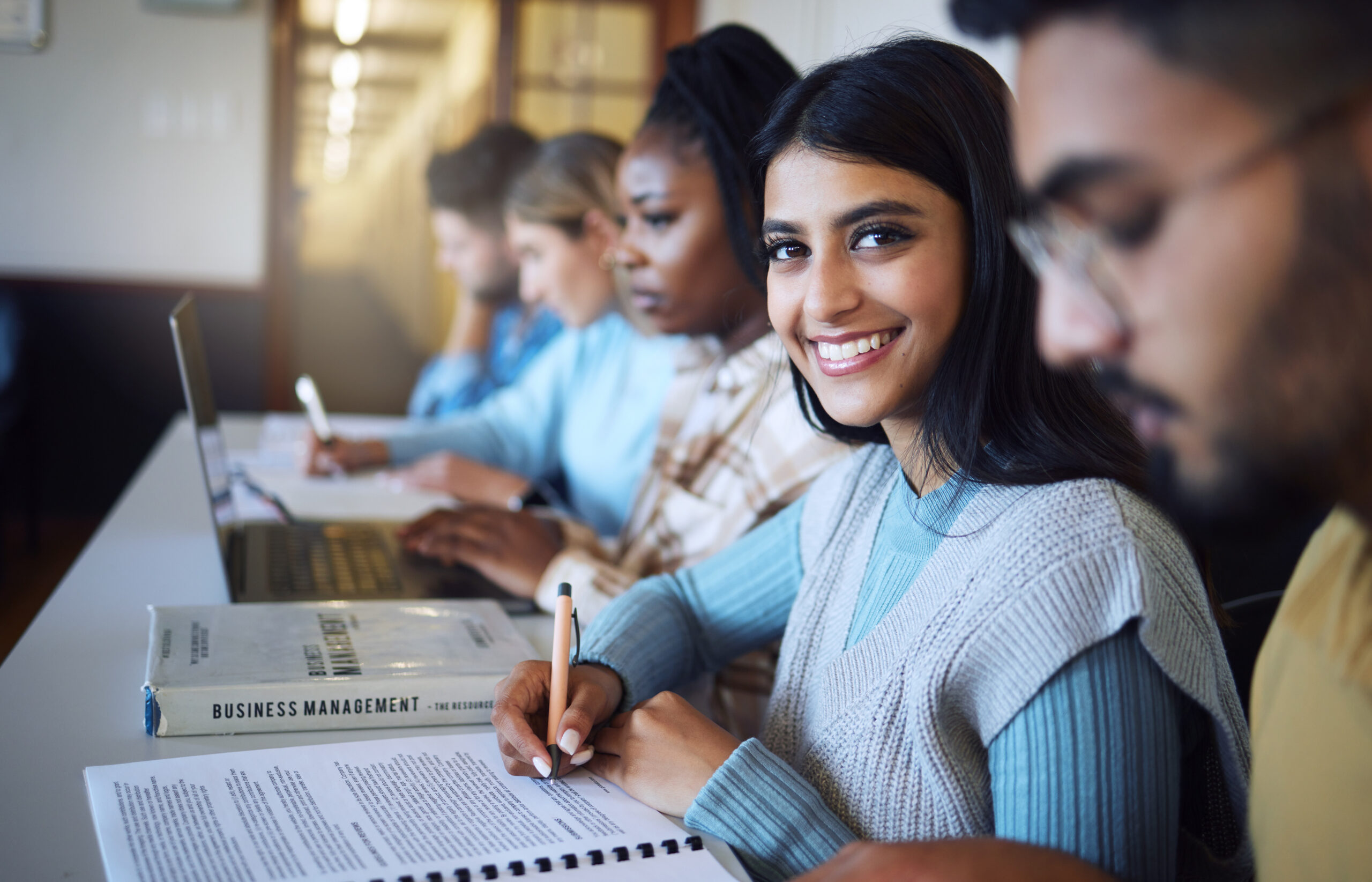Stanmore College -English. Portrait, young indian girl smiling and university student writing notes. happy for learning, education and studying