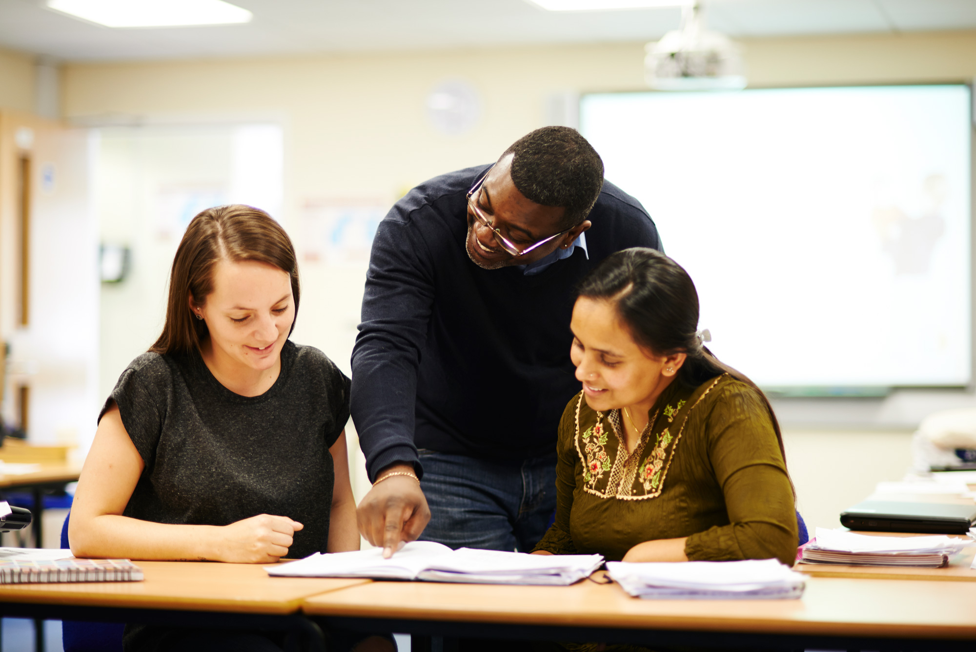 Stanmore College - Leisure and community. teacher helping 2 students in classroom