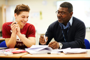 teacher helping student classroom