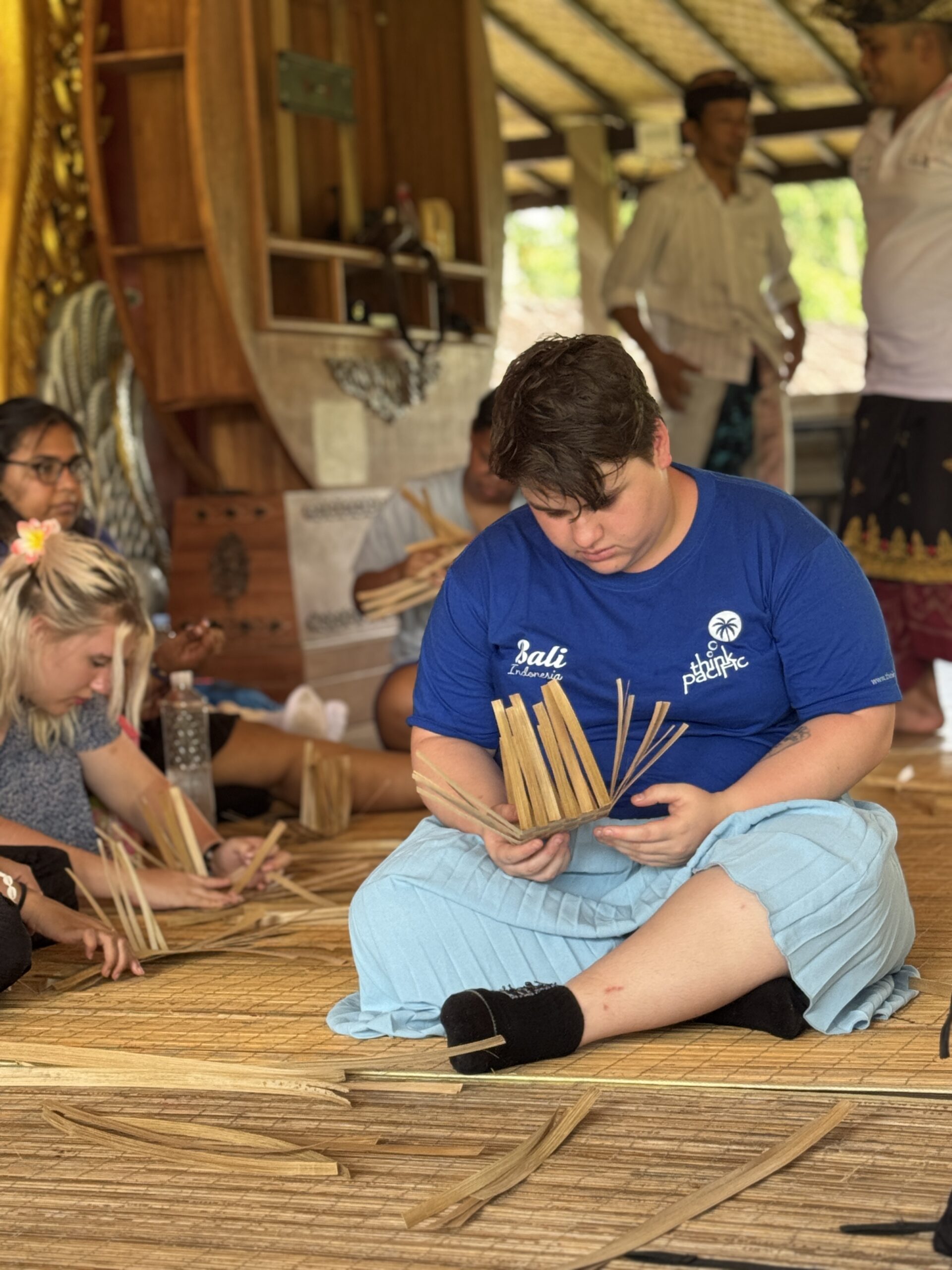 Student in Bali learning basket weaving.