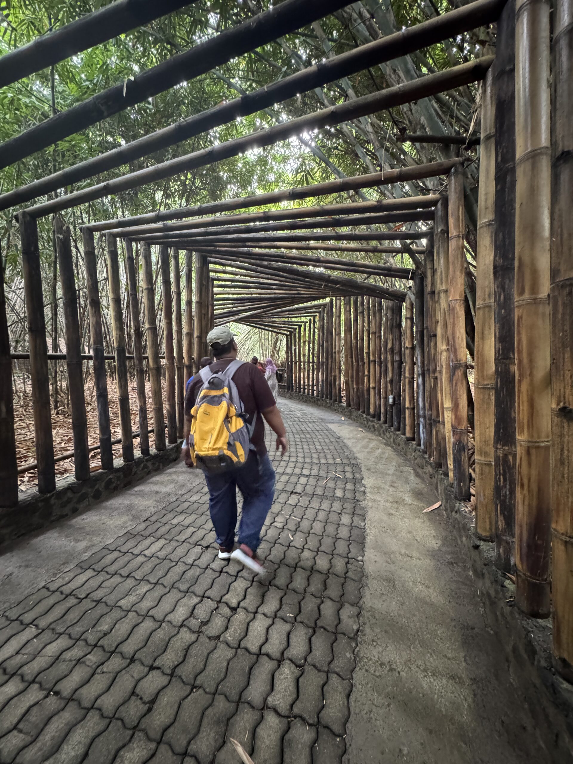 Stanmore College student walking in Bali under wooden structures