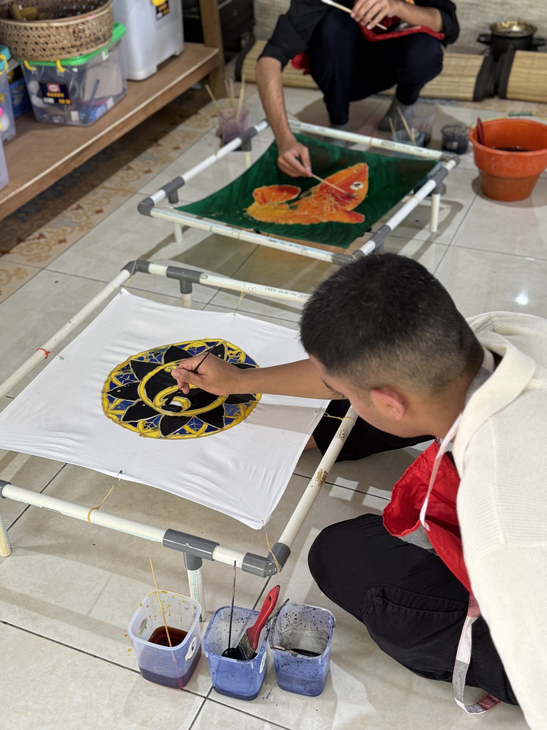 Student painting on Batik canvas