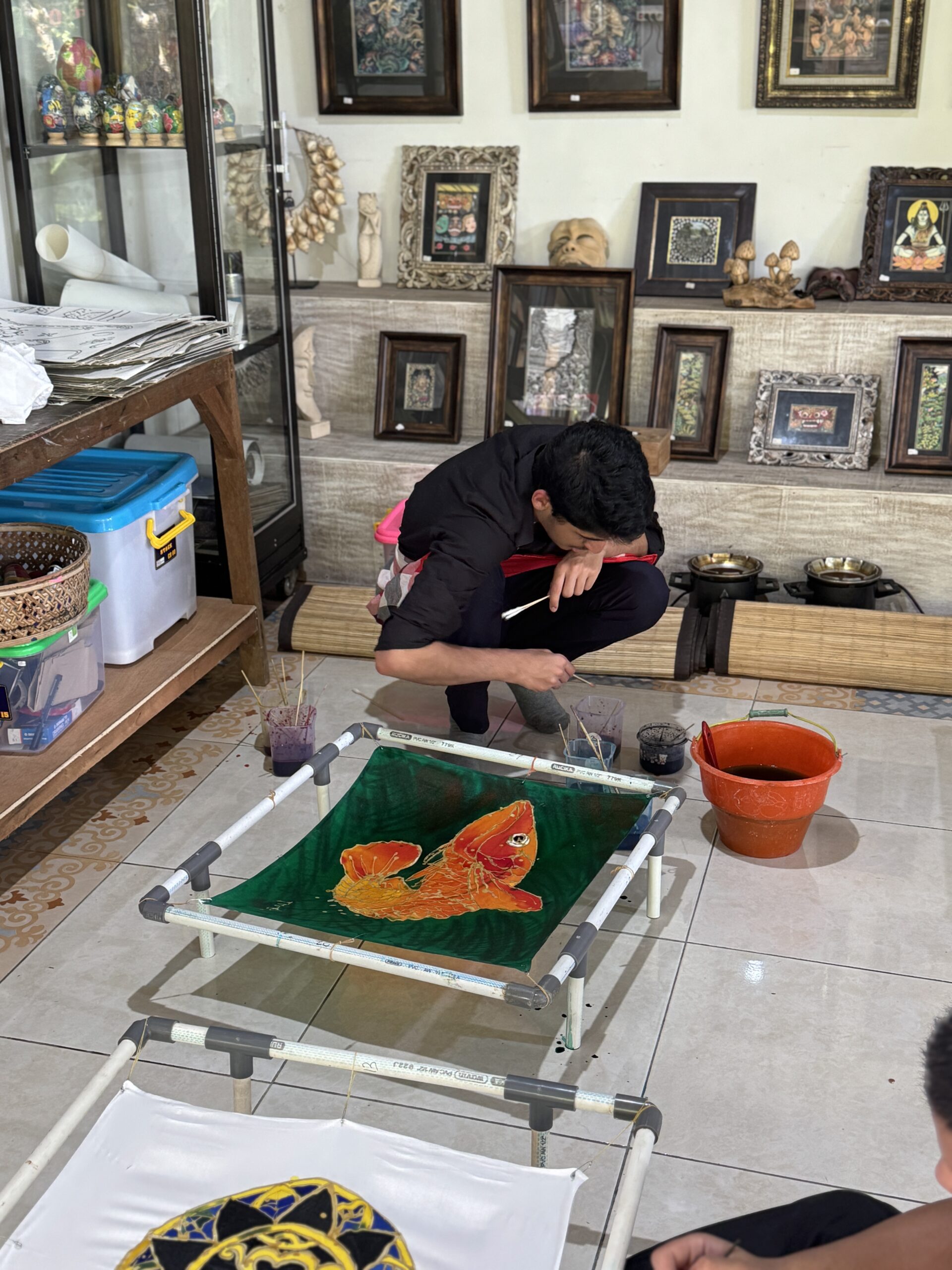 Student painting on Batik canvas