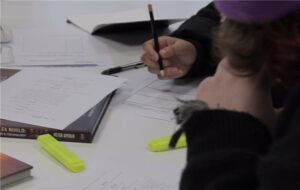 Person's hand writing with pencil and paper