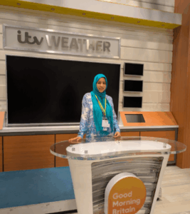 Woman standing in front of presenter desk at ITV studios.