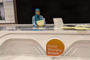 Woman sitting in front of presenter desk at ITV studios.