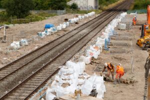 Construction workers on site next to a section of railway track.