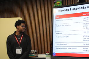 Anthony James presenting in front of screen.