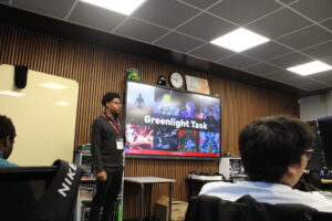 Anthony James presenting in front of screen.