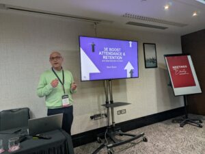 Stanmore College - Speaker Oliver Rosen in front of screen displays at National T Level Conference, June 2026.